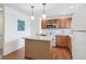 Functional kitchen boasts wooden cabinets, hardwood floors, and central island with ample counter space at 11386 Grove St # B, Westminster, CO 80031