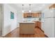 Functional kitchen boasts wooden cabinets, hardwood floors, and central island with ample counter space at 11386 Grove St # B, Westminster, CO 80031