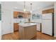 Functional kitchen boasts wooden cabinets, hardwood floors, and central island with ample counter space at 11386 Grove St # B, Westminster, CO 80031