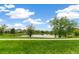 Scenic view of a tranquil pond surrounded by lush greenery and clear blue skies at 11386 Grove St # B, Westminster, CO 80031