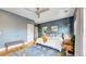 Comfortable bedroom featuring a ceiling fan, blue accent wall, and stylish decor at 1960 S Sherman St, Denver, CO 80210