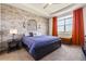 Cozy bedroom featuring a stone accent wall, tray ceiling and ample natural light at 25019 E Alder Dr, Aurora, CO 80016