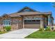 Stone-accented home with a brown two-car garage door and well-manicured front yard at 25019 E Alder Dr, Aurora, CO 80016