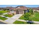 Low aerial view of stone accented home with a manicured lawn, brown roof, and two car garage at 25019 E Alder Dr, Aurora, CO 80016