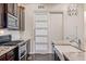 A kitchen with a large farmhouse sink, stainless steel appliances, and a white sliding pantry door at 25019 E Alder Dr, Aurora, CO 80016
