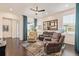 Bright living room featuring a dark hardwood floor, three reclining chairs, and natural light at 25019 E Alder Dr, Aurora, CO 80016