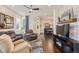 Open-concept living room with hardwood floors, plush seating, and a decorative stone accent wall at 25019 E Alder Dr, Aurora, CO 80016