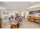 Open basement living room with seating, a dining table, a wet bar, and access to the stairs at 25019 E Alder Dr, Aurora, CO 80016