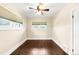 Empty bedroom featuring hardwood floors, neutral paint, multiple windows, and a ceiling fan at 3123 N Elizabeth St, Denver, CO 80205
