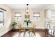 Bright dining room with modern light fixture, glass-top table, view to kitchen at 3123 N Elizabeth St, Denver, CO 80205