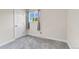 A bright bedroom featuring carpet floors, a window with curtains, and a door to the rest of the home at 7933 Chase Cir # 182, Arvada, CO 80003