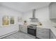 Charming kitchen with light grey cabinetry, stainless steel oven and large sunny window at 1580 S Krameria St, Denver, CO 80224
