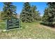 View of Judge Joseph E. Cook Park sign amid lush greenery and mature trees on a sunny day at 1580 S Krameria St, Denver, CO 80224