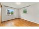 Sunlit bedroom features hardwood floors and two large windows providing ample light at 8675 Calvin Dr, Arvada, CO 80002