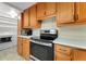 Practical kitchen featuring wood cabinets and modern appliances adjacent to the laundry area at 8675 Calvin Dr, Arvada, CO 80002