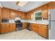 Functional kitchen with wooden cabinets, tile countertops, and stainless steel appliances at 8675 Calvin Dr, Arvada, CO 80002