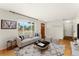 Cozy staged living room showcasing hardwood floors, ample natural light, and neutral decor at 8675 Calvin Dr, Arvada, CO 80002