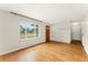 Bright living room featuring gleaming hardwood floors and a large window providing natural light at 8675 Calvin Dr, Arvada, CO 80002