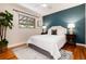 Serene bedroom with a plush bed, a striking accent wall, and hardwood flooring at 2415 Pontiac St, Denver, CO 80207