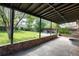 Covered patio overlooking a well-maintained backyard with mature trees and greenery at 2415 Pontiac St, Denver, CO 80207