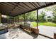 Outdoor patio with grilling station, seating area, and a view of the fenced backyard with mature trees at 2415 Pontiac St, Denver, CO 80207