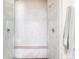 Elegant bathroom featuring a marble shower with a built-in bench and pebble stone flooring at 9575 E 3Rd Pl, Denver, CO 80230