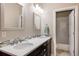 Modern bathroom with double vanity, sleek mirrors, and a view of the shower area at 9575 E 3Rd Pl, Denver, CO 80230
