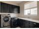 Functional laundry room with modern washer and dryer, ample counter space, and storage at 9575 E 3Rd Pl, Denver, CO 80230