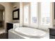 Elegant main bathroom featuring a large soaking tub and vanity with ample sunlight at 9575 E 3Rd Pl, Denver, CO 80230