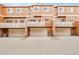Exterior view of brown townhomes with garages at 18061 E Saskatoon Pl, Parker, CO 80134