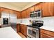 Modern kitchen with stainless steel appliances, white countertops, and wood cabinetry at 18061 E Saskatoon Pl, Parker, CO 80134