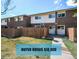 A charming townhouse with a brick facade, a well-maintained lawn, and a wooden fence at 8019 Wolff # G, Westminster, CO 80031