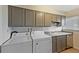 A practical laundry area with grey cabinets, utility sink, and modern washing machine and dryer at 8019 Wolff # G, Westminster, CO 80031