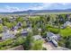 Panoramic aerial view of a suburban neighborhood with lush greenery and mountain views in the background at 9926 W Nova Pl, Littleton, CO 80127