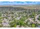 Extensive aerial view showing a large neighborhood dotted with trees, green spaces, and distant bodies of water at 9926 W Nova Pl, Littleton, CO 80127
