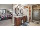Ensuite bathroom featuring a dual sink vanity, a large mirror, and a step-in shower in a neutral palette at 9926 W Nova Pl, Littleton, CO 80127