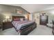 Spacious primary bedroom suite with room for a king bed, dresser, and private entry to ensuite bathroom at 9926 W Nova Pl, Littleton, CO 80127