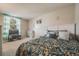 Bright bedroom with leafy patterned comforter and large window providing ample natural light and outdoor views at 9926 W Nova Pl, Littleton, CO 80127