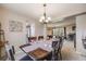 Open dining room with decorative lighting fixture, wood table and chairs, and easy access to the living room at 9926 W Nova Pl, Littleton, CO 80127
