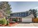 Charming two-story home with blue siding, brick accents, a well-manicured lawn, and a spacious two car garage at 9926 W Nova Pl, Littleton, CO 80127