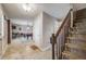 Spacious foyer with tiled floors, staircase, and view into the living room with a pool table at 9926 W Nova Pl, Littleton, CO 80127