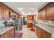 Well-lit kitchen with stainless steel appliances and cherry wood cabinetry and granite countertops at 9926 W Nova Pl, Littleton, CO 80127