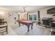 Bright living room featuring a pool table, neutral carpet, large window and comfortable seating at 9926 W Nova Pl, Littleton, CO 80127