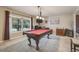 Cozy living room with a pool table, plush carpet, a large window, and neutral color palette at 9926 W Nova Pl, Littleton, CO 80127