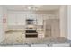 Well-equipped kitchen featuring granite countertops, stainless steel appliances, and sleek white cabinets at 5550 W 80Th Pl # 1, Arvada, CO 80003