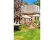 Lush backyard featuring a brick home with a patio area set for dining and manicured landscaping at 334 Ivy St, Denver, CO 80220