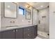 Modern bathroom featuring double sinks, sleek gray cabinets, and a glass-enclosed shower at 1928 W 41St Ave, Denver, CO 80211