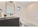 Clean bathroom featuring a dark vanity, modern fixtures, and a minimalist design with a shower-tub combination at 1928 W 41St Ave, Denver, CO 80211