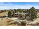 Aerial view of charming home with acreage, mature trees, and white fencing at 10963 N Chatfield Dr, Littleton, CO 80125