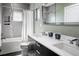 Modern bathroom featuring double vanity, large mirror, and shower-tub combination with white shower curtain at 3453 Navajo St, Denver, CO 80211